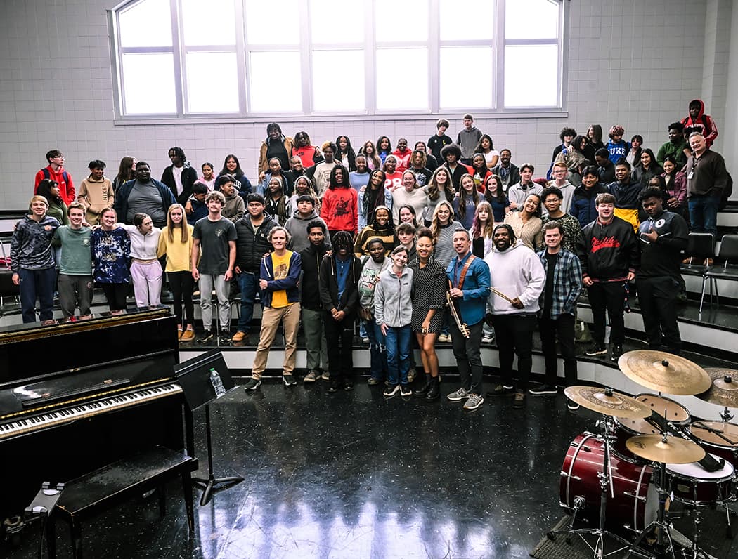 Students posed together on stage risers after a jazz masterclass