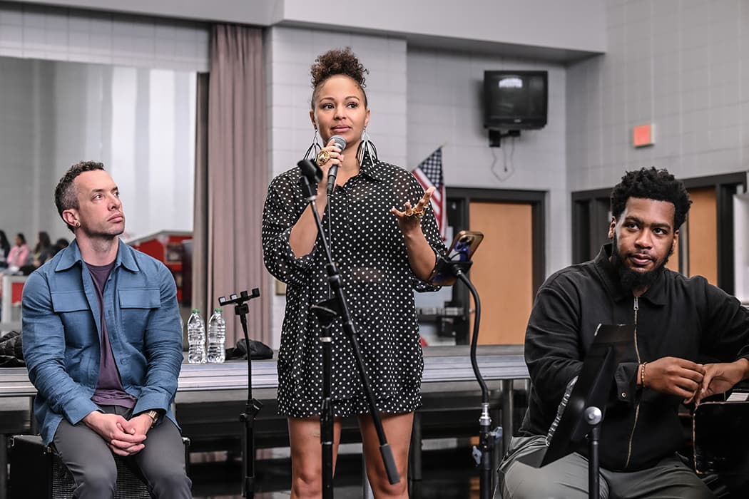 A vocalist speaking with students during a school visit