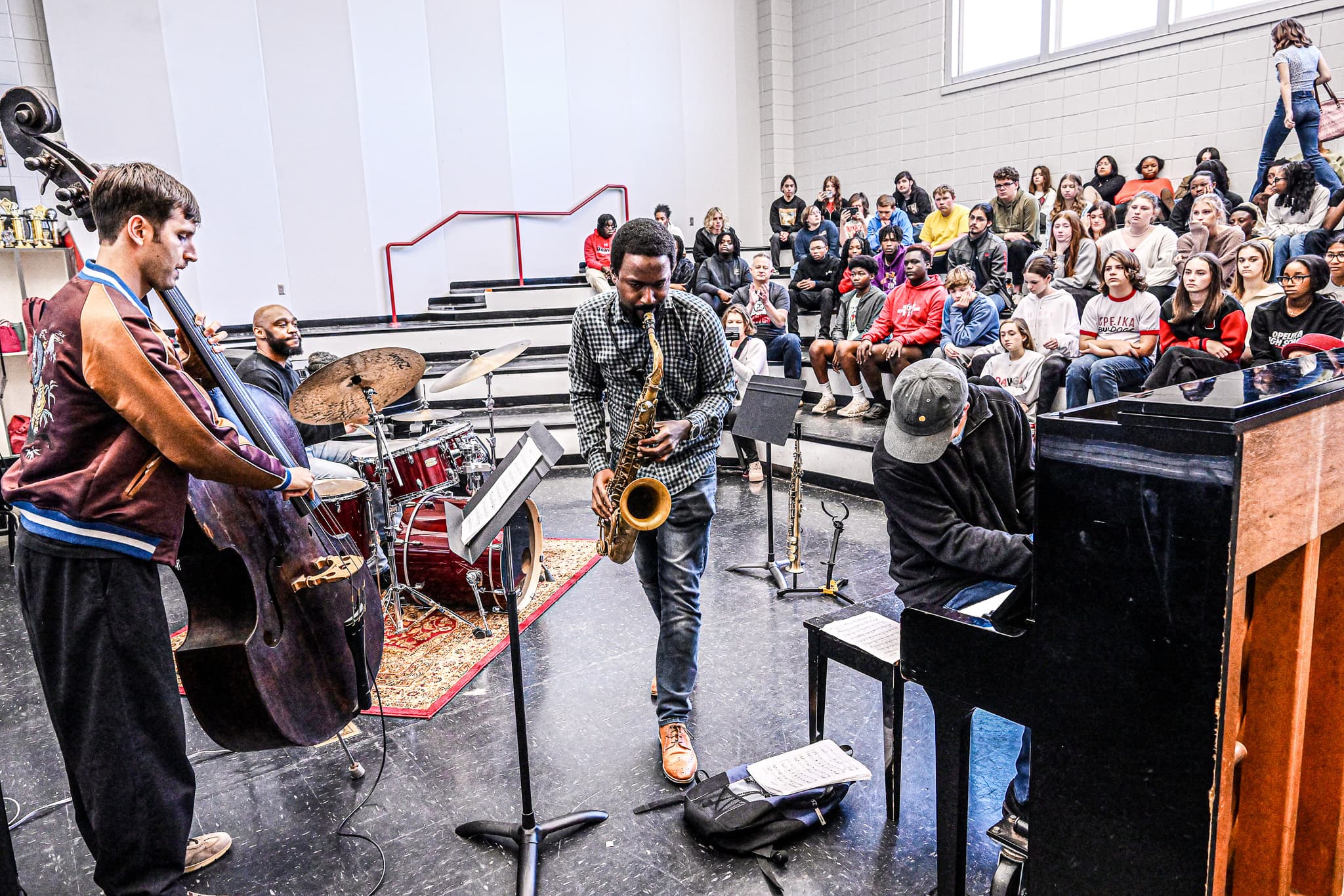 A band performing for high school students seated on bleachers