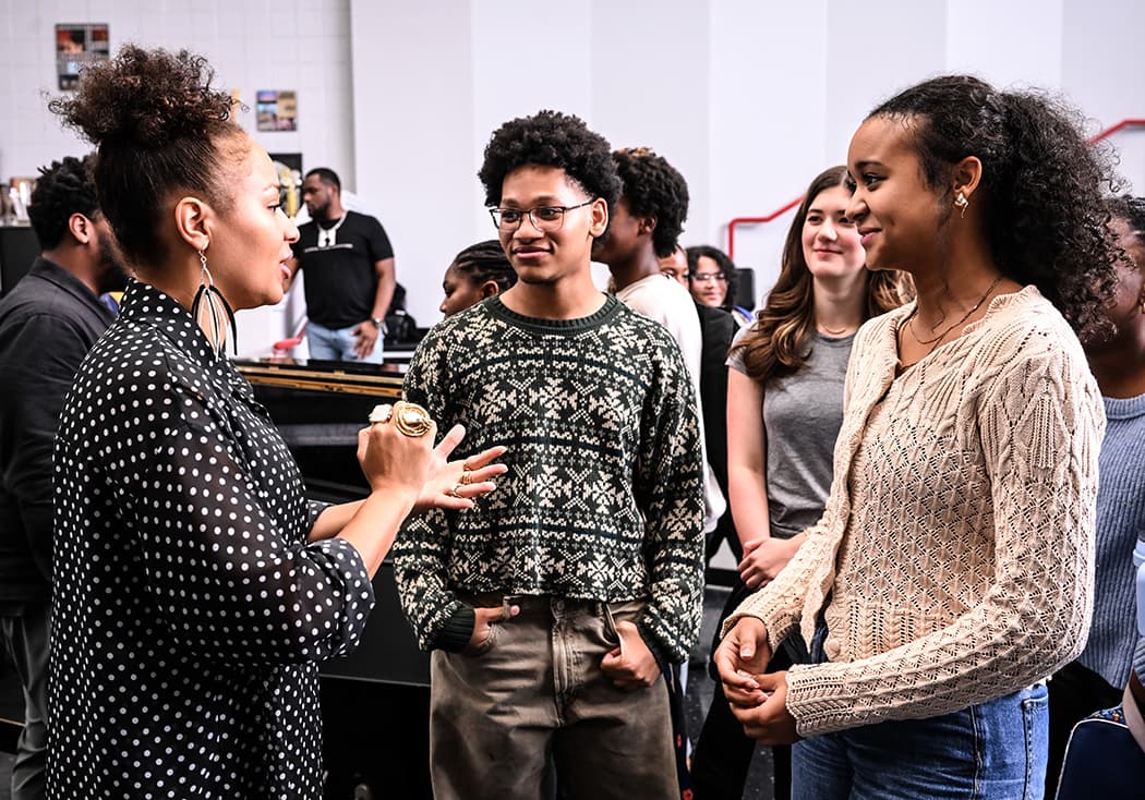 A visiting artist talking with students after a school visit