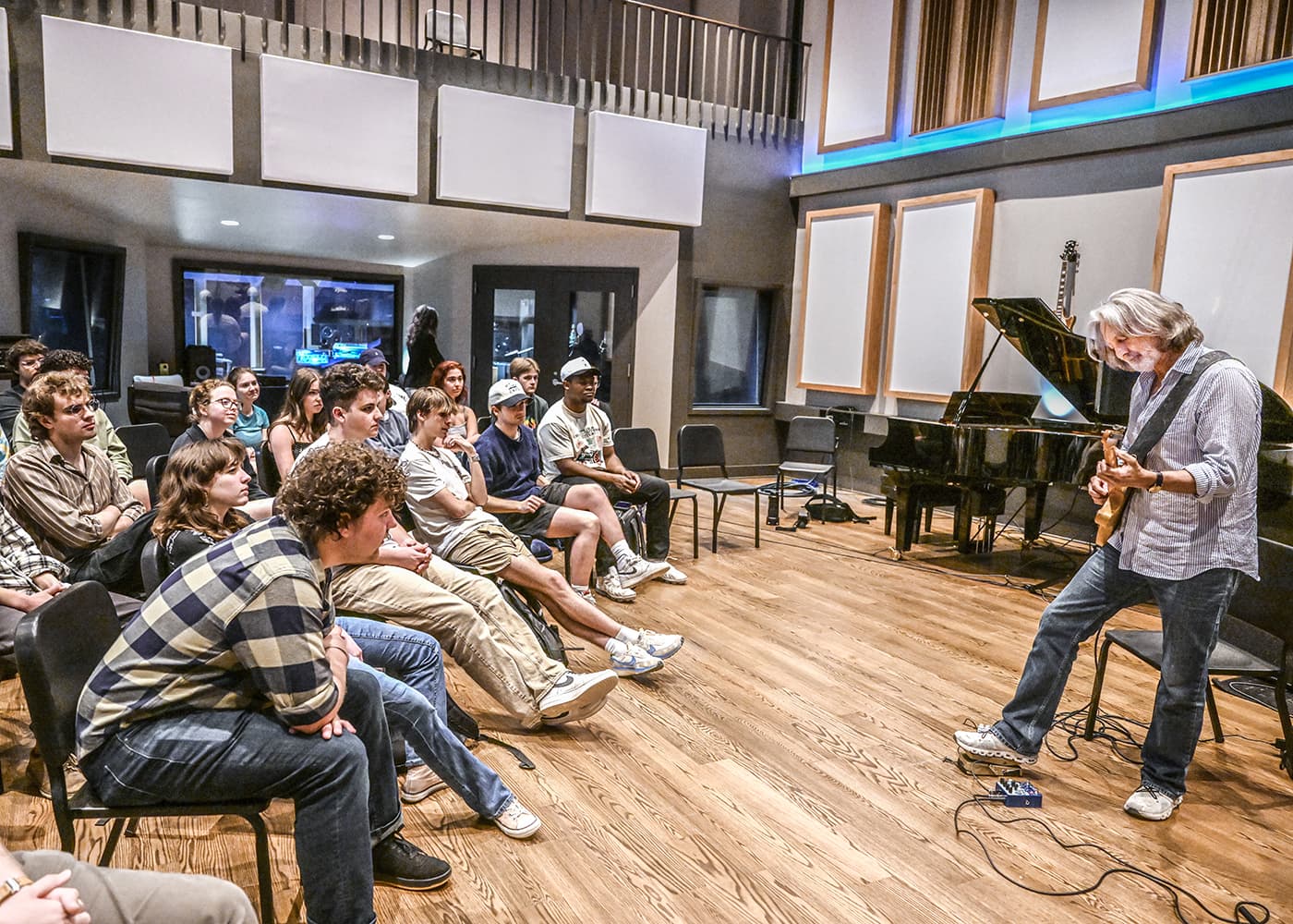 A guitarist leads a masterclass in the Sound Wall studio