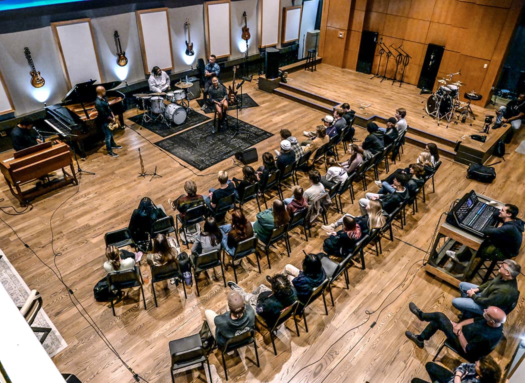 Overhead view of a full band leading a workshop for a seated audience
