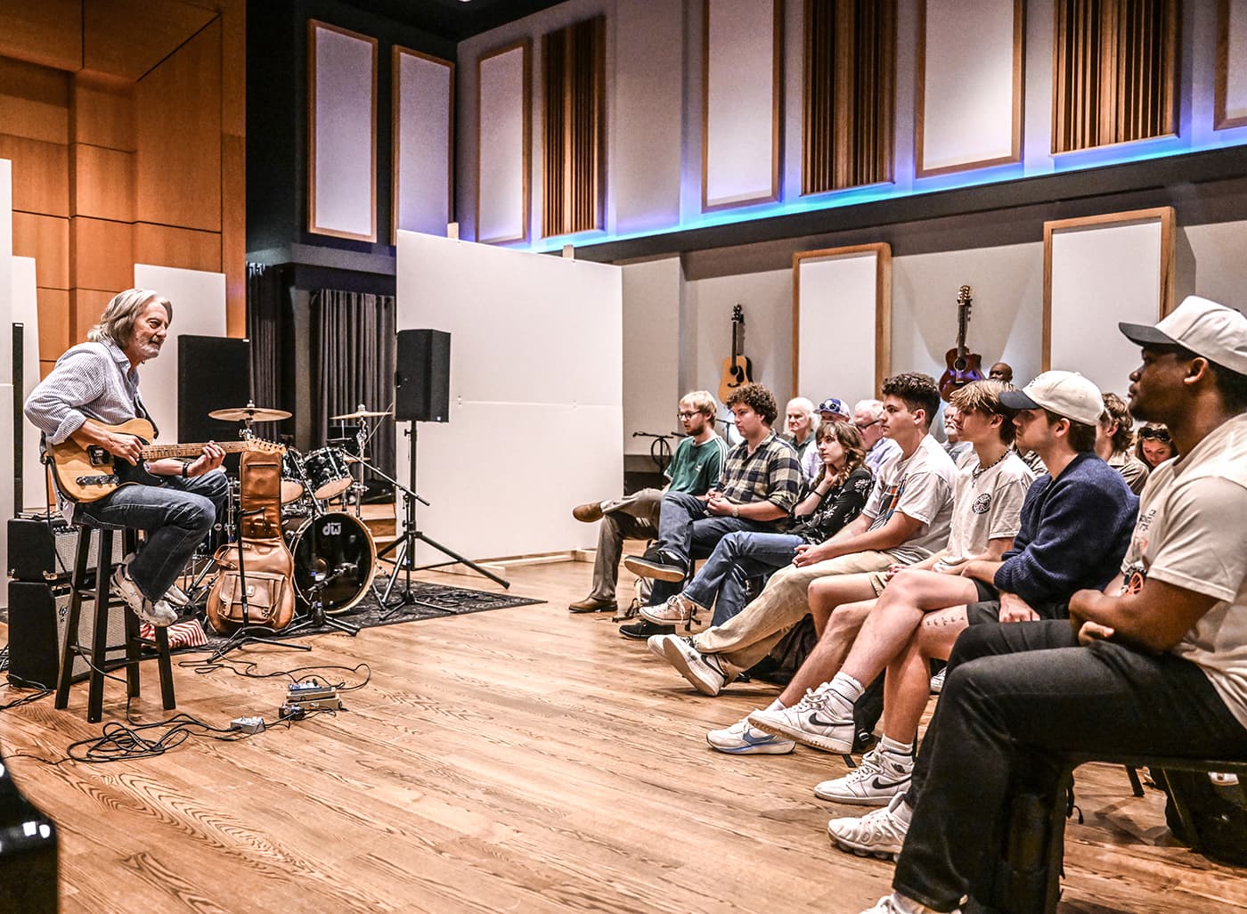 A musician performing on stage for workshop attendees