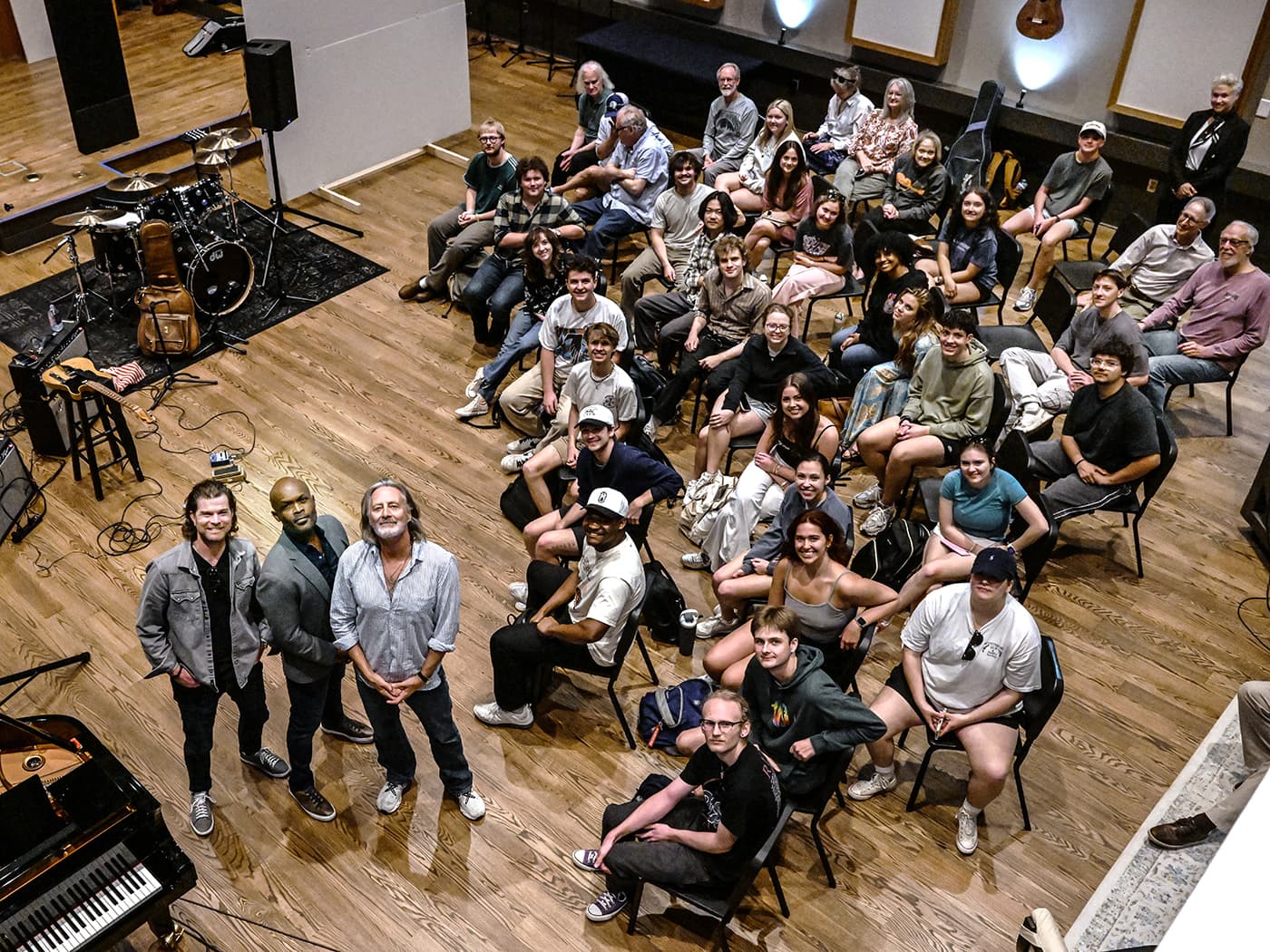 Workshop attendees and artists smiling together in the studio
